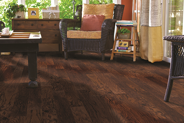 hickory flooring in the living room with dark brown straw chair